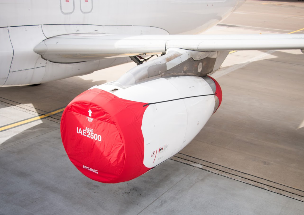 A close up of the side of an airplane with Aviatema equipment aircraft engine intake cover.